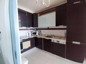 a kitchen with dark brown cabinets and a sink at Holidays in blue in Olhos de Água
