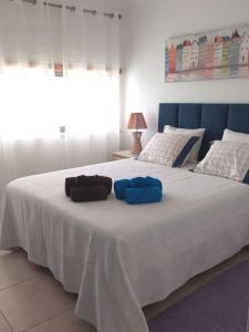 a large white bed with two pillows on it at Holidays in blue in Olhos de Água