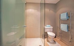 ein Bad mit einem WC und einer Glasdusche in der Unterkunft TOWNHOUSE with ROOFTOP by Hyde Park in London