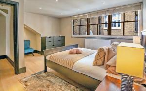 Schlafzimmer mit einem Bett und einem Fenster in der Unterkunft TOWNHOUSE with ROOFTOP by Hyde Park in London