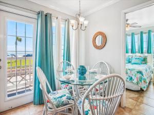 a dining room with a glass table and chairs at Victorian 8104-Gulf Dreams in Galveston