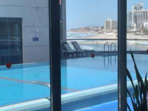 vista para uma piscina a partir de um quarto de hotel em Marina vaction rentals em Herzliya B