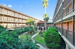 an apartment building with a courtyard with trees and bushes at Victorian 8104-Gulf Dreams in Galveston