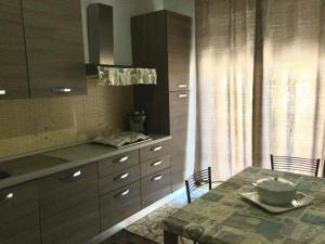 a kitchen with a table and cabinets and a dining room at Casa Akira Margot in Floridia
