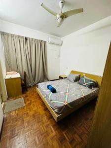 a bedroom with a bed and a ceiling fan at Batu Ferringhi Homestay in Batu Ferringhi