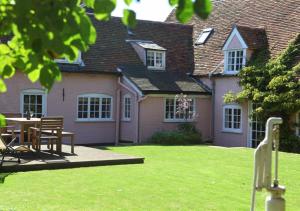 una casa con mesa y sillas en el patio en The Pump House, en Orford