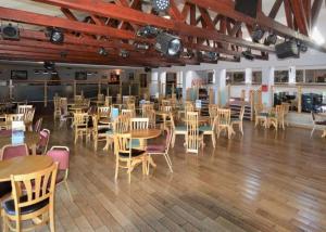un restaurante con mesas de madera y sillas en una habitación en Beacon Fell View, en Longridge
