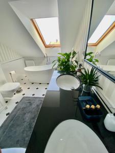 uma casa de banho com 2 lavatórios e uma banheira em Apartament Szafarnia DeLux em Gdansk