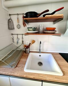 a kitchen counter with a sink and some utensils at Acogedora y romántica casita en la sierra in Garganta de los Montes