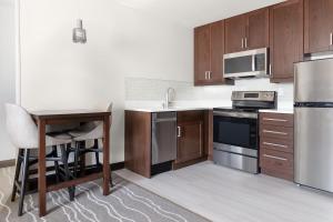 拉戈的住宿－Residence Inn Largo Medical Center Drive，厨房配有不锈钢用具和木桌
