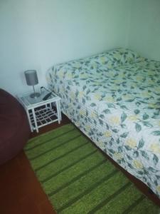 1 dormitorio con 1 cama y 1 mesa con lámpara en Casa da Praia Alfarim, en Sesimbra