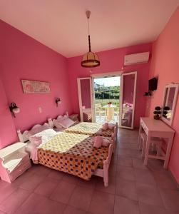 a bedroom with a large bed and a pink wall at Telis Apartments One in Roda