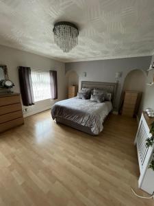 a large bedroom with a bed and a chandelier at House in Anfield in Liverpool