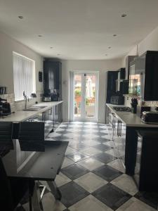 a kitchen with black and white tile floors and a door at House in Anfield in Liverpool