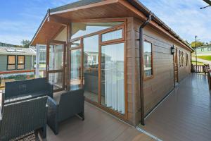ein Holzhaus mit Glastüren auf einer Terrasse in der Unterkunft Butterfly Lodge in Swanage