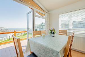a dining room with a table and a view of the ocean at Butterfly Lodge in Swanage