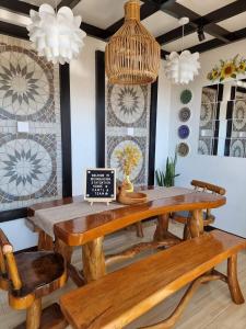 Angono的住宿－Dicimulacion Staycation House，一间带木桌和长凳的用餐室