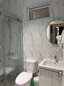 a bathroom with a toilet and a sink and a shower at Odyssey Allure in Kingston