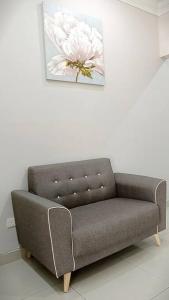 un sofá en una habitación con una foto de una flor en Port Dickson 9Pax x 3BR Single Storey House, en Port Dickson