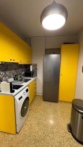 a kitchen with yellow cabinets and a refrigerator at Crown Syntagma Apartment in Athens