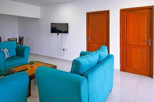 a living room with two blue chairs and a table at Lake Red 6 Apartments & Hotel in Nugegoda