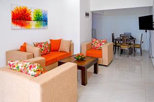 a living room with couches and a table and a tv at Lake Red 6 Apartments & Hotel in Nugegoda