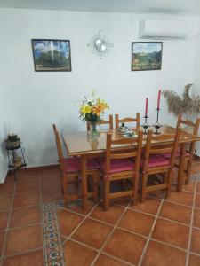 a dining room with a wooden table and chairs at Alojamiento Rural Los Barrosos in Coripe +11 photos
