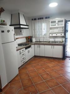 een keuken met een witte koelkast en een tegelvloer bij Alojamiento Rural Los Barrosos in Coripe