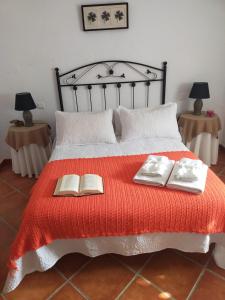 a bedroom with a bed with two books on it at Alojamiento Rural Los Barrosos in Coripe