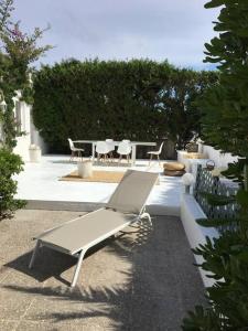 una panchina bianca seduta accanto a un tavolo e sedie di Private beautiful house - ( nice swimming Pool) a Cala'n Porter