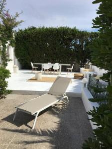 a white bench sitting next to a table and chairs at Private beautiful house - ( nice swimming Pool) in Cala'n Porter