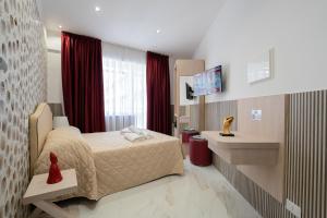 a hotel room with a bed and a television at GreRos H. Rooms Napoli Centro by Clapa Group Dislocated Hospitality in Naples
