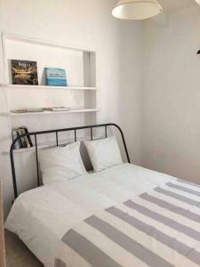 a bedroom with a bed with white sheets and a lamp at Private beautiful house - ( nice swimming Pool) in Cala en Porter +17 photos