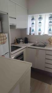 a kitchen with white cabinets and a sink at Private beautiful house - ( nice swimming Pool) in Cala'n Porter +16 photos