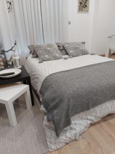 a bedroom with a bed and a table with a phone at Casa en piedra (Stone House) in Porriño