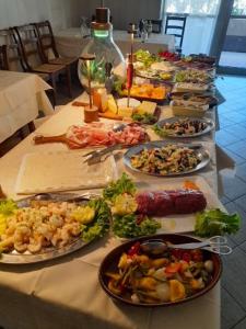 un lungo tavolo con molti piatti di cibo sopra di vasco rent rooms a Mantova