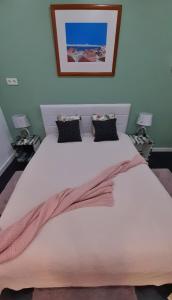 a bedroom with a large white bed with two lamps at Lisbon apartment in Lisbon