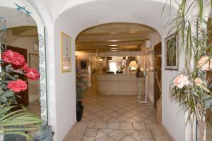 a hallway with an archway with flowers and a kitchen at Hotel Cavour in Olbia
