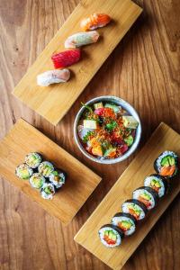 a group of four wooden cutting boards with sushi at The Grand Hotel in Kennebunk