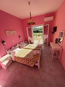 sypialnia z łóżkiem i różową ścianą w obiekcie Telis Apartments One w Rodzie