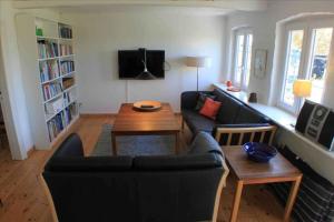 uma sala de estar com um sofá e uma mesa em Holmegrd - A Cozy Country House On The Outskirts Of Sby em Soby Mark