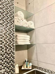 een badkamer met handdoeken op planken in een badkamer bij Familienapartment in Wien in Wenen