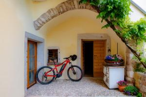 una bicicleta roja estacionada frente a una casa en Agriturismo Maso Giomo, en Brentonico