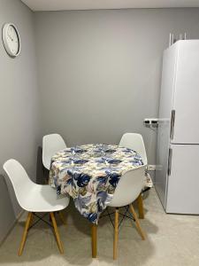 een keuken met een tafel en stoelen en een koelkast bij Hygge Apartment in Mizhhirya