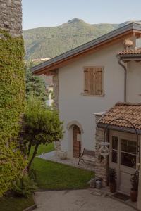 una casa blanca con un banco en un patio en Agriturismo Maso Giomo en Brentonico