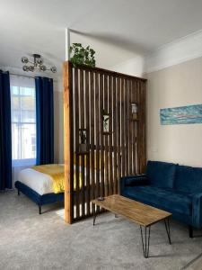 a living room with a bed and a blue couch at Norton house in Brighton & Hove