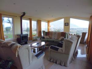uma grande sala de estar com sofás e uma lareira em Estancia La Quinta em El Chaltén