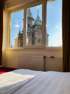 een slaapkamerraam met uitzicht op een kasteel bij Joy City Stay Victoriei 7G-9 in Timişoara