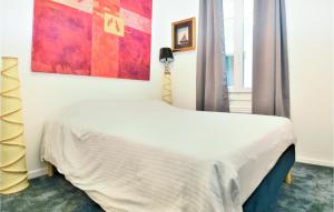 - une chambre avec un lit blanc orné d'une peinture murale dans l'établissement Gorgeous Home In Sommires With Wifi, à Sommières