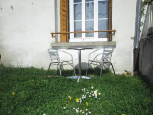 two chairs sitting on a table in front of a window at Appartement Rez de chaussée Résidence les Oliviers in Langeac